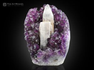 A 14 cm scalenohedral calcite crystal is dramatically perched on a richly colored amethyst matrix from Uruguay.