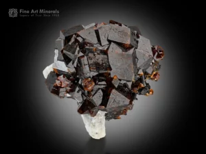 Reddish-brown andradite garnet crystals with sharp form on white feldspar matrix.