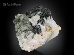 Hematite crystals with adularia and chlorite sprays exhibit a mirror-like luster and a strong irradiance effect.