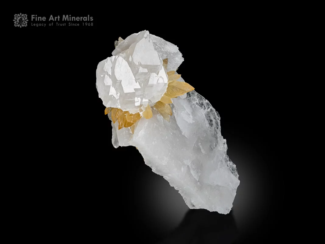 Transparent lustrous quartz crystal with golden calcite cluster on matrix.