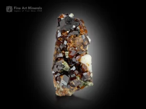 Sharp reddish-brown andradite garnet crystals with bright luster and green-white matrix from Balochistan, Pakistan.