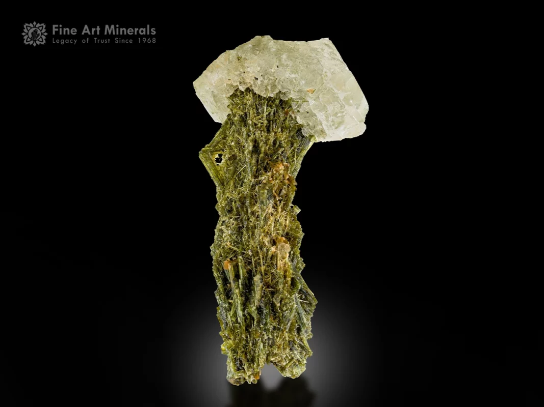 Lustrous green epidote crystals with a white adularia crystal on top from Kharan, Pakistan.