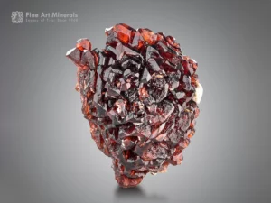 Deep red spessartine garnet with crisp reflective faces and a slight albite accent.