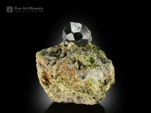 Dark green demantoid garnet crystal on a contrasting matrix from South Asia.