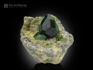 Deep green demantoid garnet crystal on a contrasting matrix with exceptional luster and clarity.