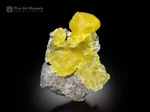 Vivid lemon-yellow brucite crystals perched on matrix with broad glowing surfaces.