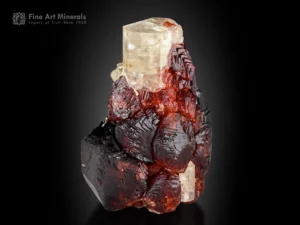 Pink apatite crystal with red spessartine garnet cluster showing yellow UV fluorescence.
