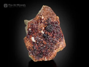 Dense spessartine garnet crystals with deep red color on a natural matrix.