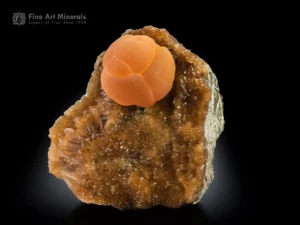 Rounded orange calcite ball on matrix with calcite coverage and a second calcite sphere on the back.