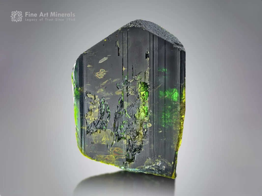 Dark epidote specimen from Pakistan showing vivid, bright green flashes when backlit, with a strong crystal form.