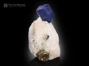 deep blue lazurite crystal perched on white marble matrix with a pyrite cluster