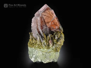 Sharply terminated axinite crystal on matrix with vibrant green epidote association