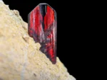 Fiery red phantom brookite crystal with sharp termination on an earthy tone matrix.