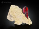 Fiery red phantom brookite crystal with sharp termination on an earthy tone matrix.