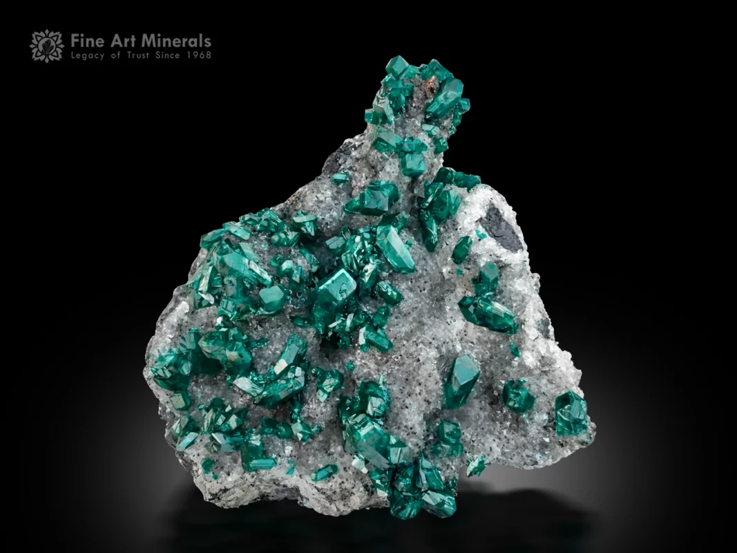 Vibrant emerald green dioptase crystals on contrasting matrix from Tsumeb Mine, Namibia.