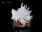 White calcite crystal cluster with sharp terminations on a brown matrix.