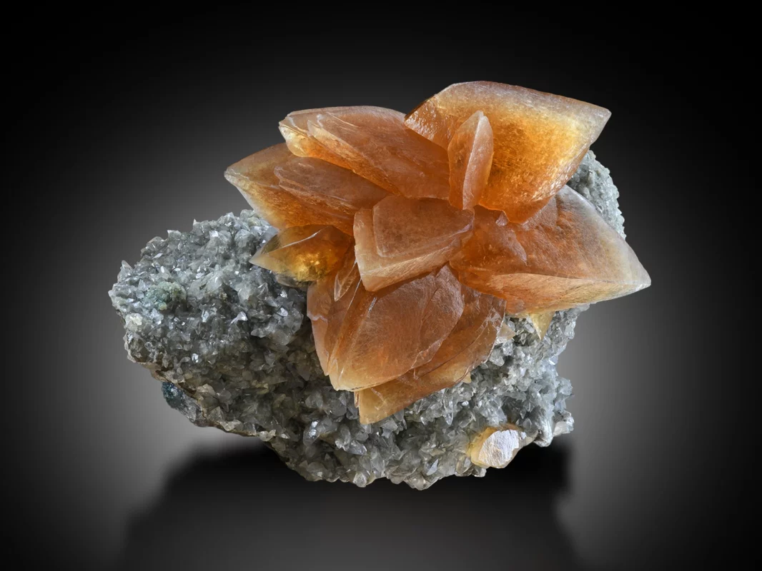 Collection of calcite crystals showing varied colors and crystal forms on matrix.