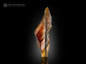 Epidote crystal with faden layer inclusion from Pakistan, glowing warm under backlight.