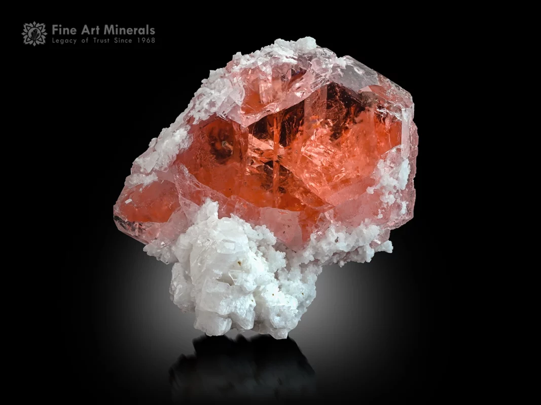 Gemmy pink fluorite crystal with glassy luster on white albite matrix.