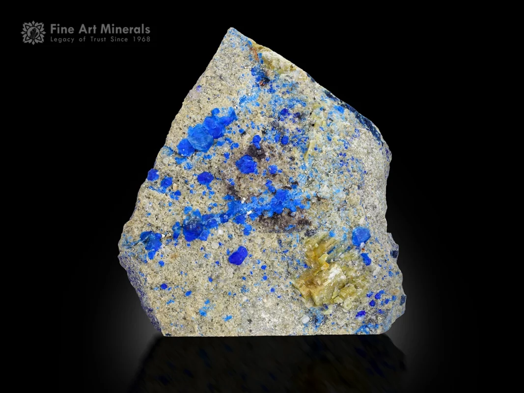 Blue hauyne crystals on matrix showing orange fluorescence under UV light.