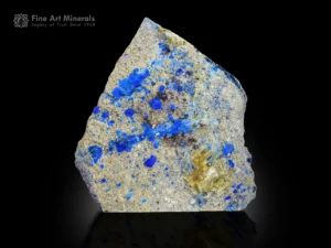 Blue hauyne crystals on matrix showing orange fluorescence under UV light.