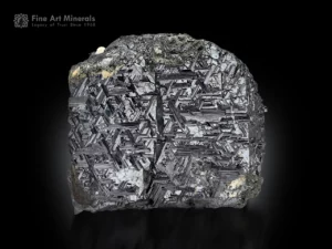 Metallic hematite crystals covered with fine rutile needles, forming a dense, textured pattern