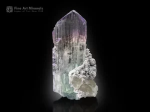 Large kunzite crystal with lilac pink color zoning, quartz crystals, and green tourmaline on matrix.