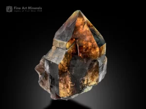 Large quartz crystal with rutile inclusions showing internal glow and pointed termination.