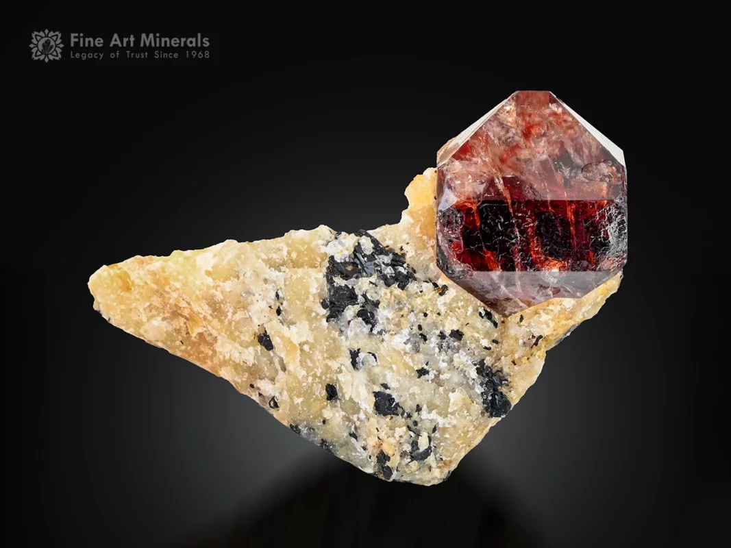 Red zircon crystal with glassy luster on a natural matrix, self-standing