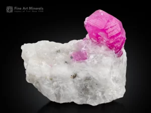 Ruby crystal on matrix glowing under UV light fluorescent corundum specimen.