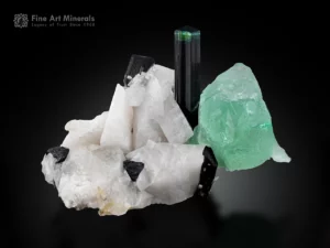 Tourmaline crystals with green fluorite on white feldspar matrix, mineral specimen.