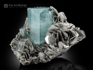Sky-blue aquamarine crystal with two smaller crystals on a silvery muscovite matrix from Nagar Valley.