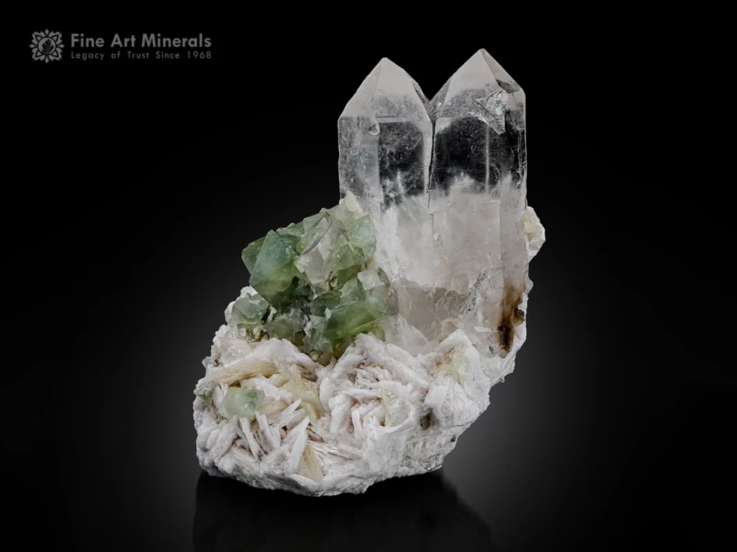 Parallel-grown quartz crystals with green herderite and muscovite on albite matrix.