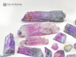 Mixed lot of Kunzite crystals showing lilac and green colors with natural crystal forms and good clarity.