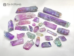 Mixed lot of Kunzite crystals showing lilac and green colors with natural crystal forms and good clarity.