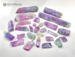 Mixed lot of Kunzite crystals showing lilac and green colors with natural crystal forms and good clarity.