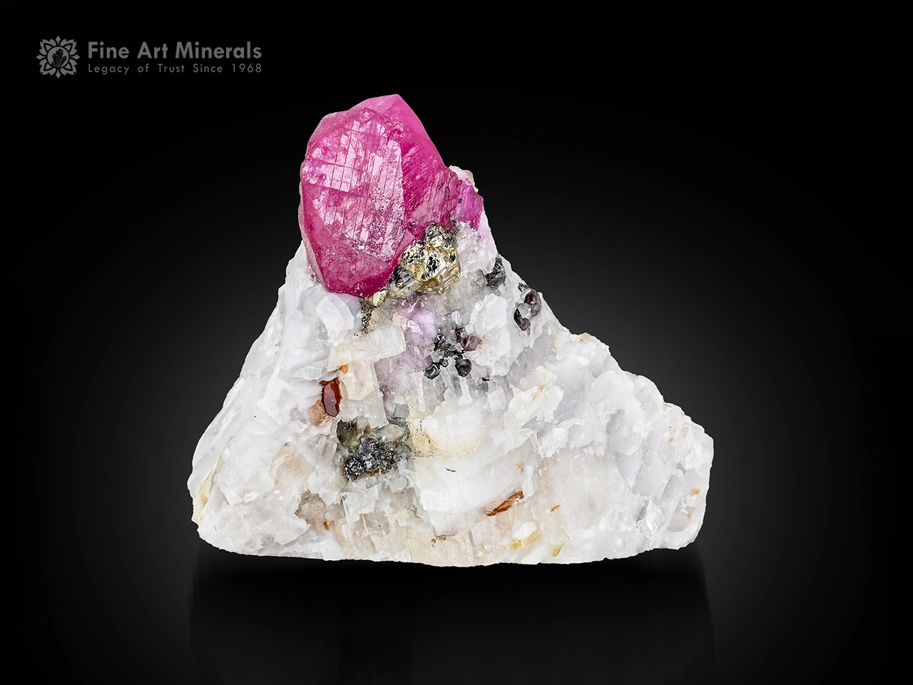 Vivid pink corundum var. ruby crystal with pyrite on white matrix from Afghanistan.