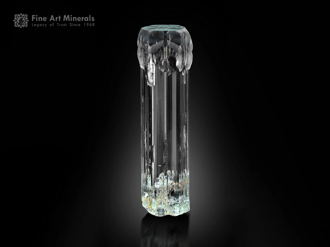 Transparent aquamarine crystal with etched formations, flat termination, and pristine rehealed base.