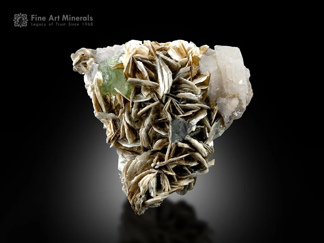 Pale green fluorite crystal associated with bladed muscovite and feldspar matrix.