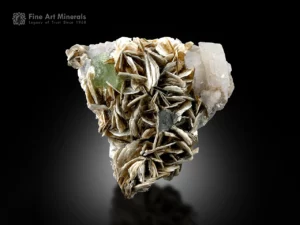 Pale green fluorite crystal associated with bladed muscovite and feldspar matrix.