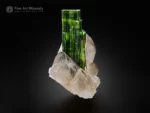 Green tourmaline crystal with flat termination growing on quartz matrix.