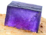 Deep purple Fluorite cube with sharp geometry on contrasting hard matrix.