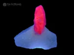 3 cm ruby crystal on white calcite matrix displaying strong orange fluorescence under UV light