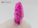 3 cm ruby crystal on white calcite matrix displaying strong orange fluorescence under UV light