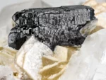 Lustrous Tantalite-(Mn) crystal associated with Quartz, Topaz, Albite, and Muscovite.